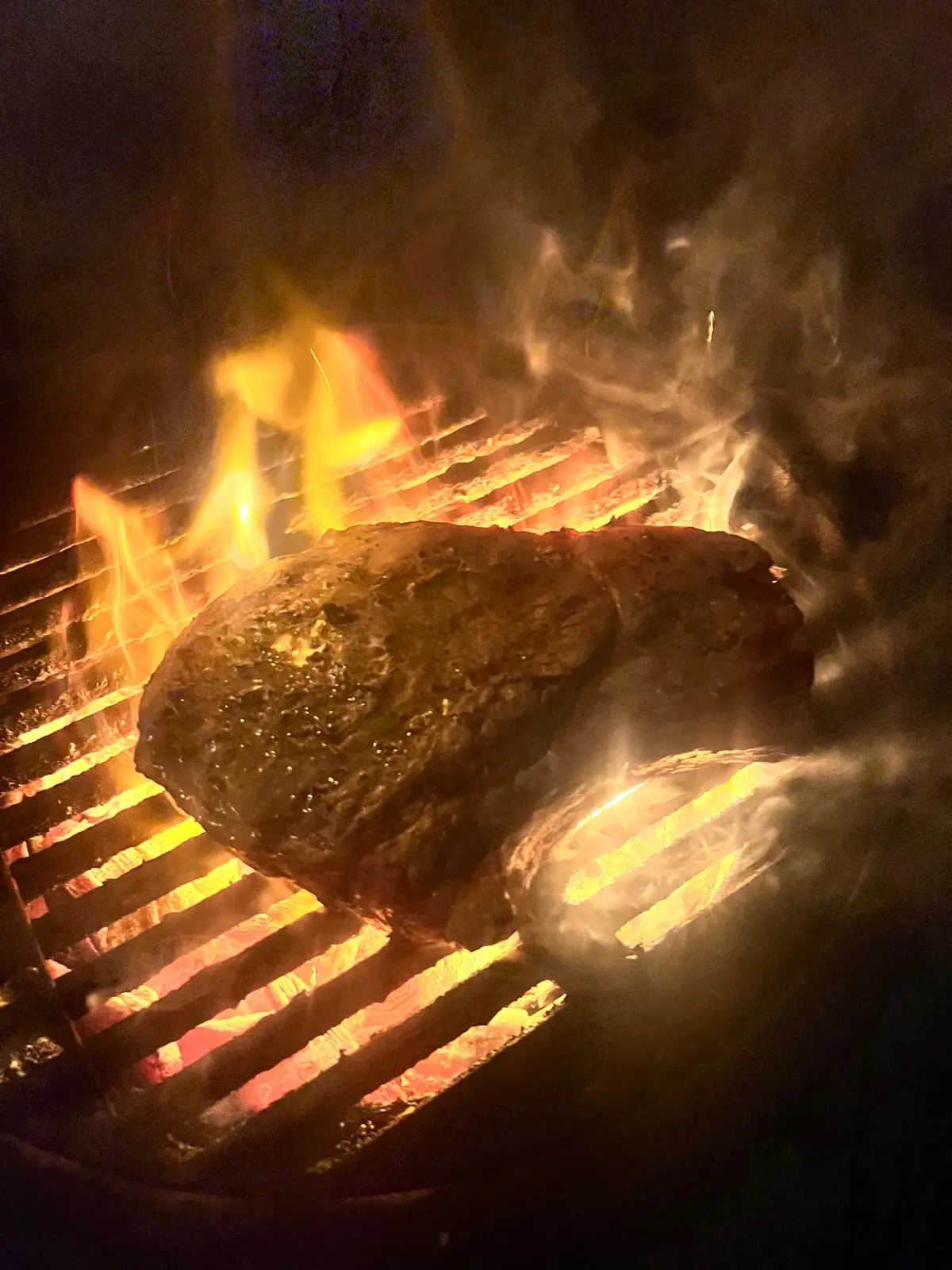 Custom ribeye cooking over live charcoal on a Big Green Egg MiniMax