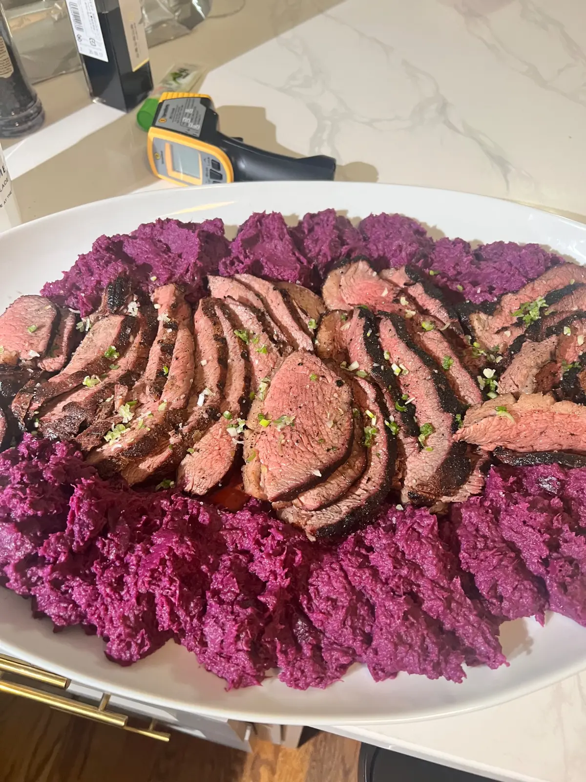 Grilled filet sliced over purple cauliflower puree with a savory herb finish
