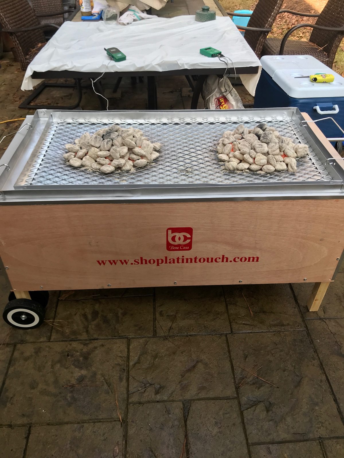 Charcoal arranged on the top tray of the wooden roasting box