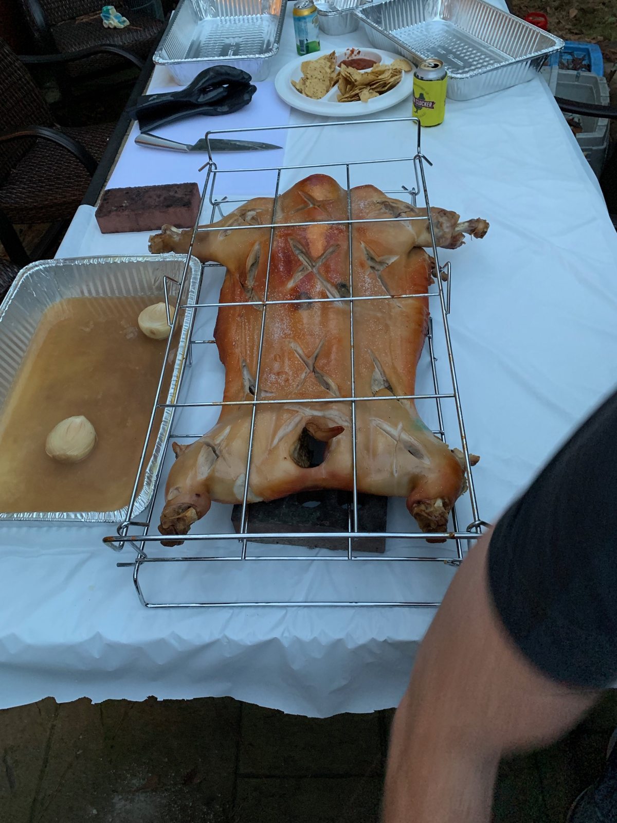 Finished whole hog in its rack on an outdoor serving table in Brookhaven