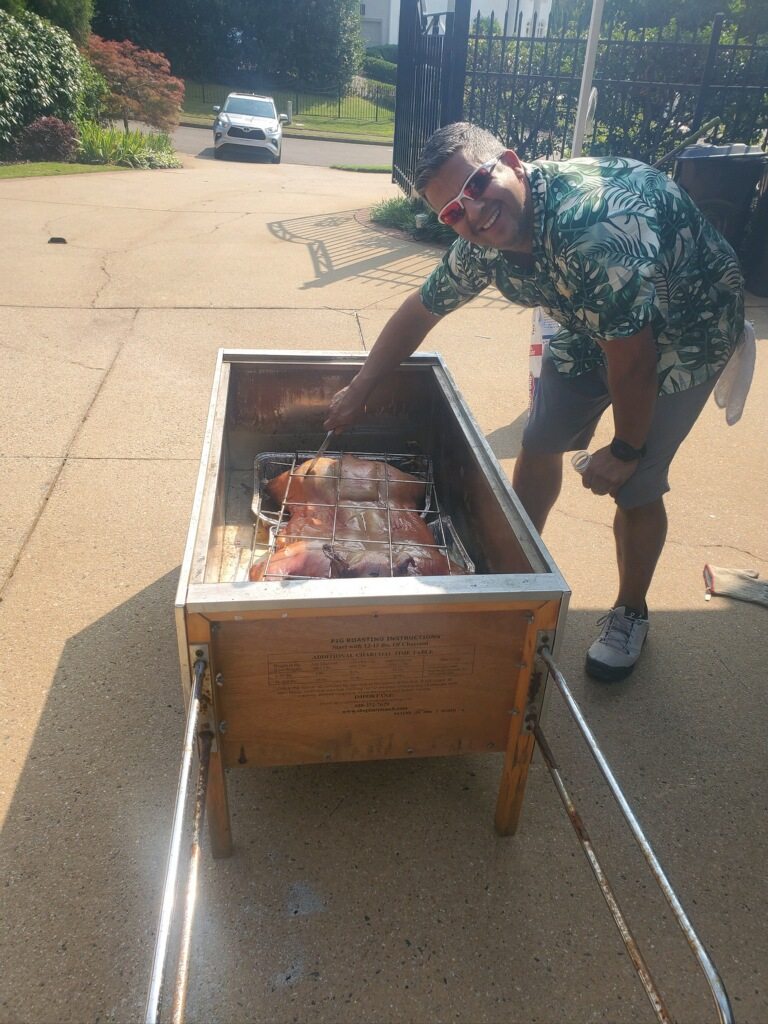 Dan tending the whole hog in the roasting box at the divorce party