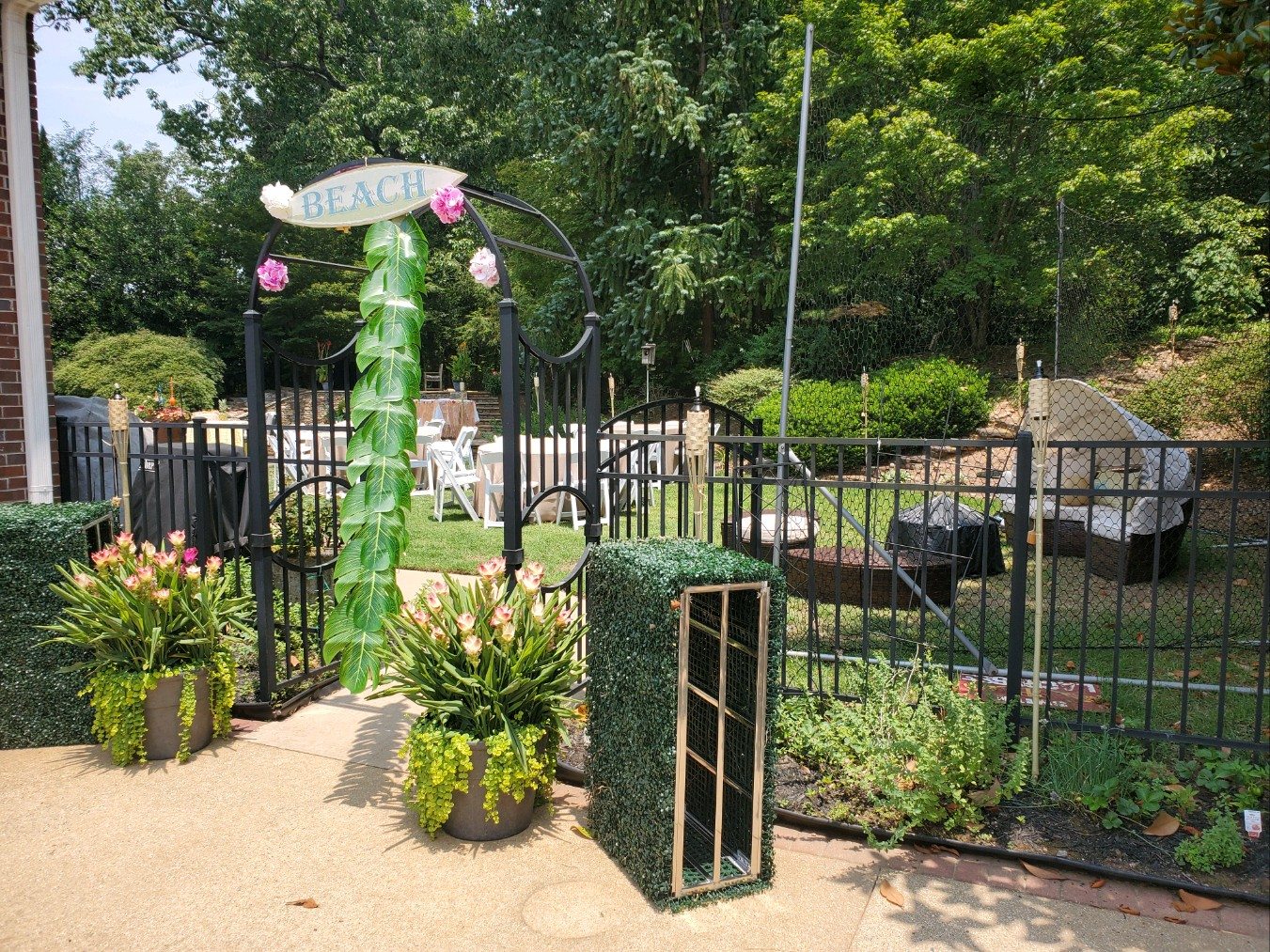 Decorated garden gate and path leading into the outdoor luau party