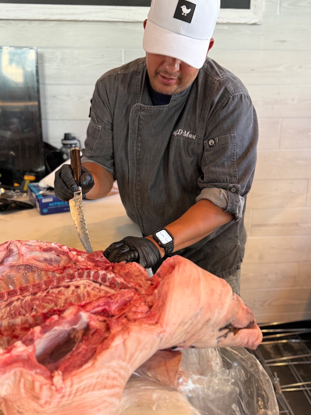 Dan preparing a butterflied hog with a knife at Frazie’s